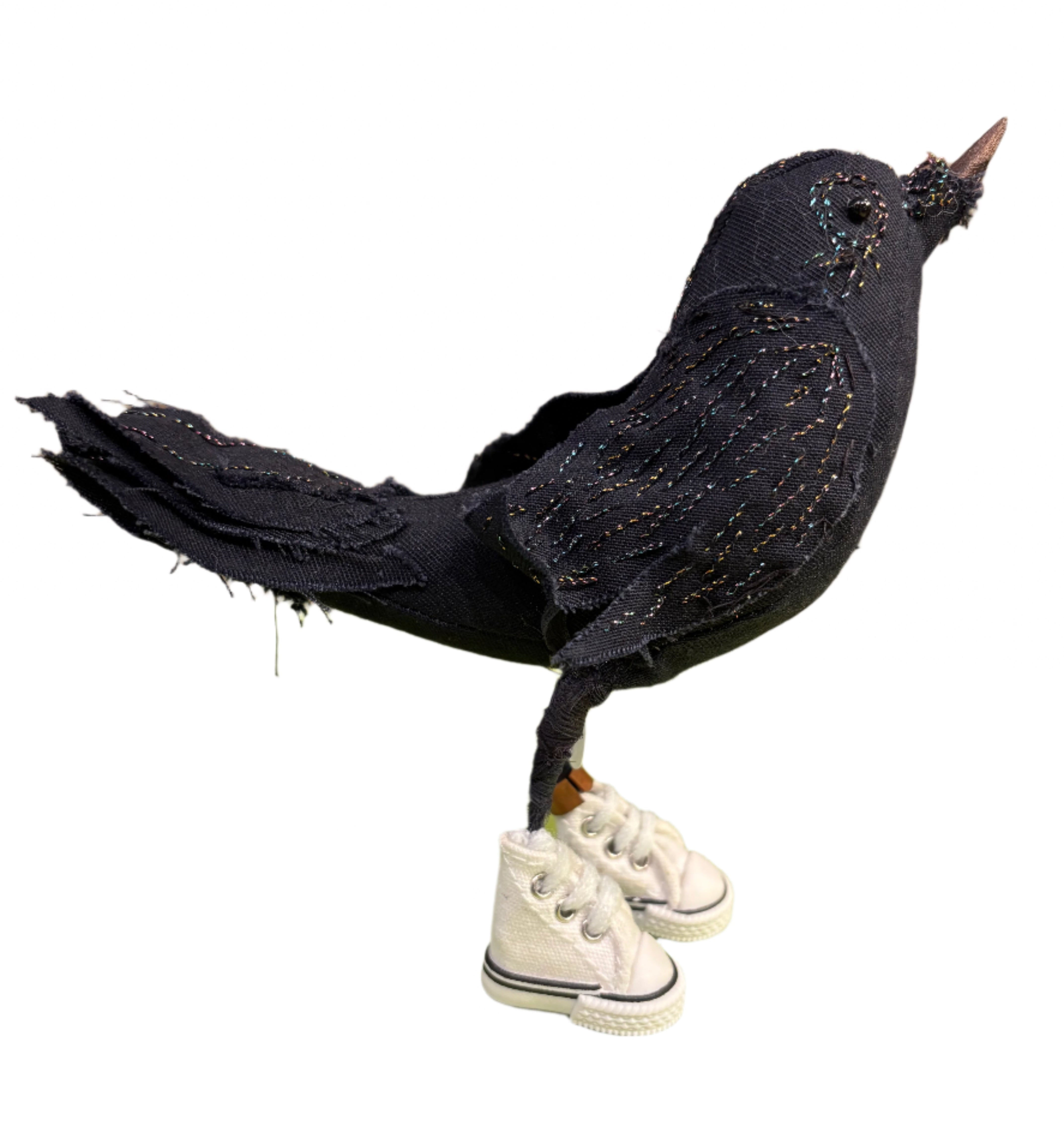 Handmade black fabric bird in white sneakers on white background
