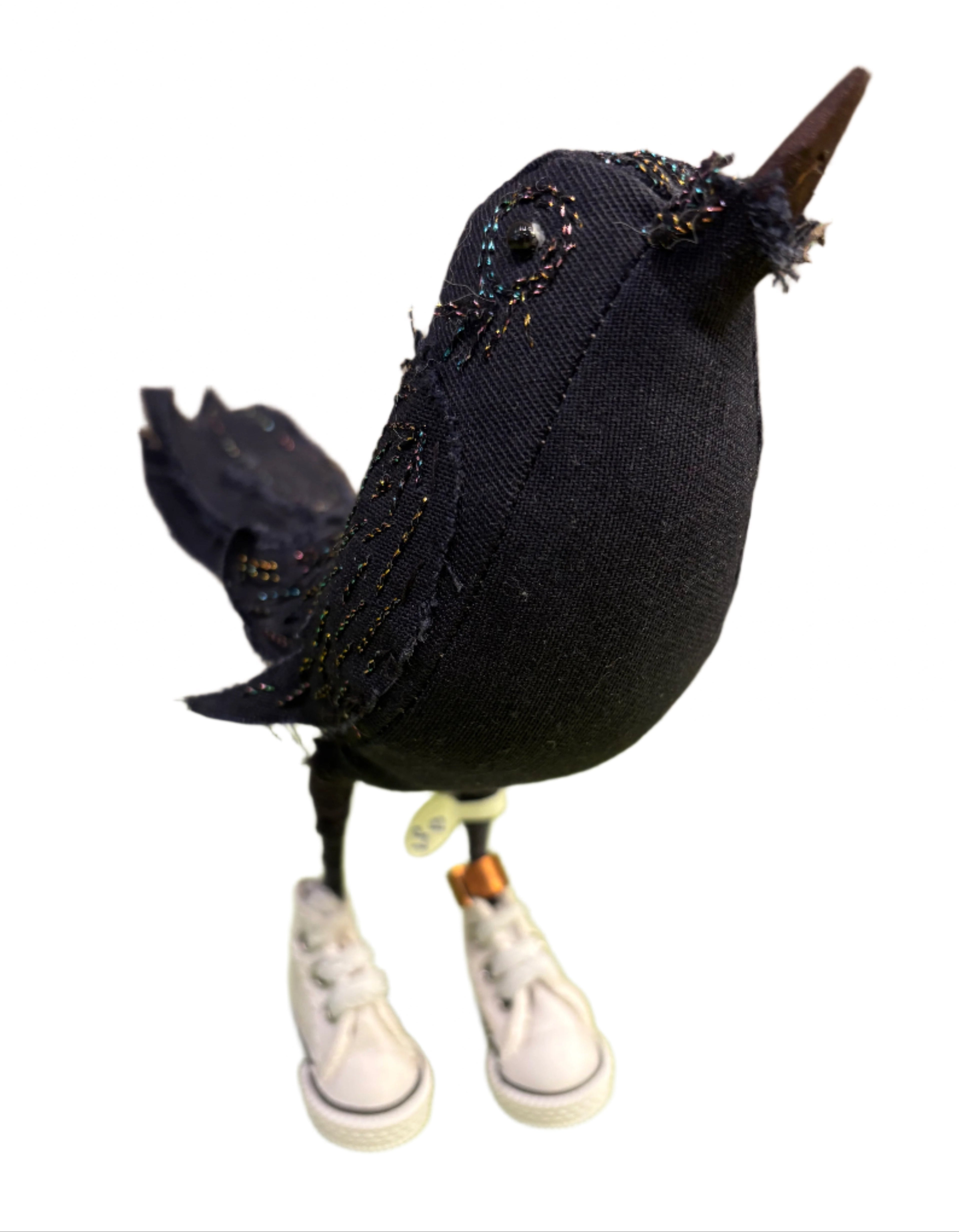 Black fabric bird with white sneakers on a white background